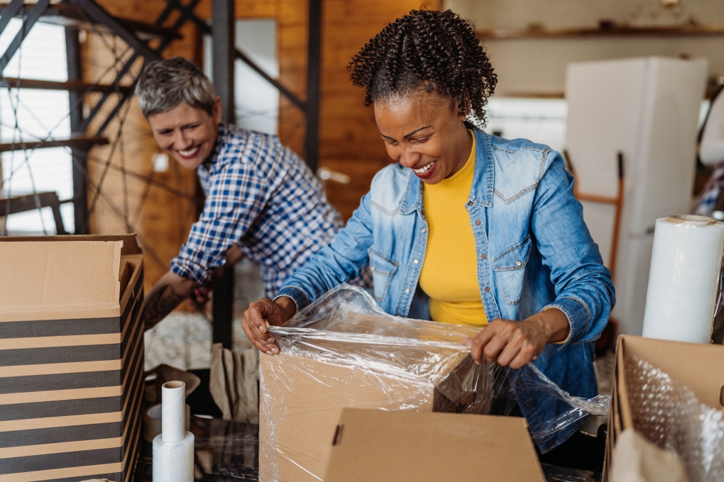Photo for article on the cost of moving illustrating two women packing boxes 